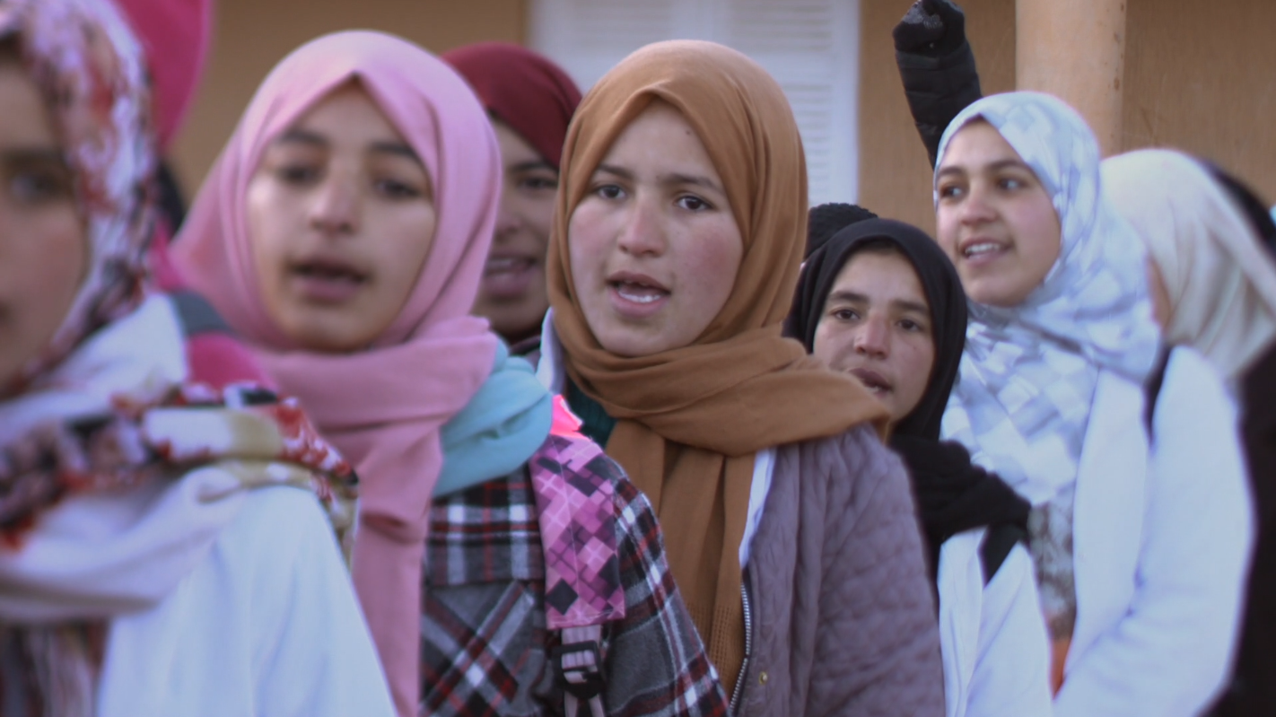 Les jeunes filles de l'école communautaire de Zaouiat Ahansal, capturées en train de chanter l'hymne national. Crédit photo : ONU Femmes 