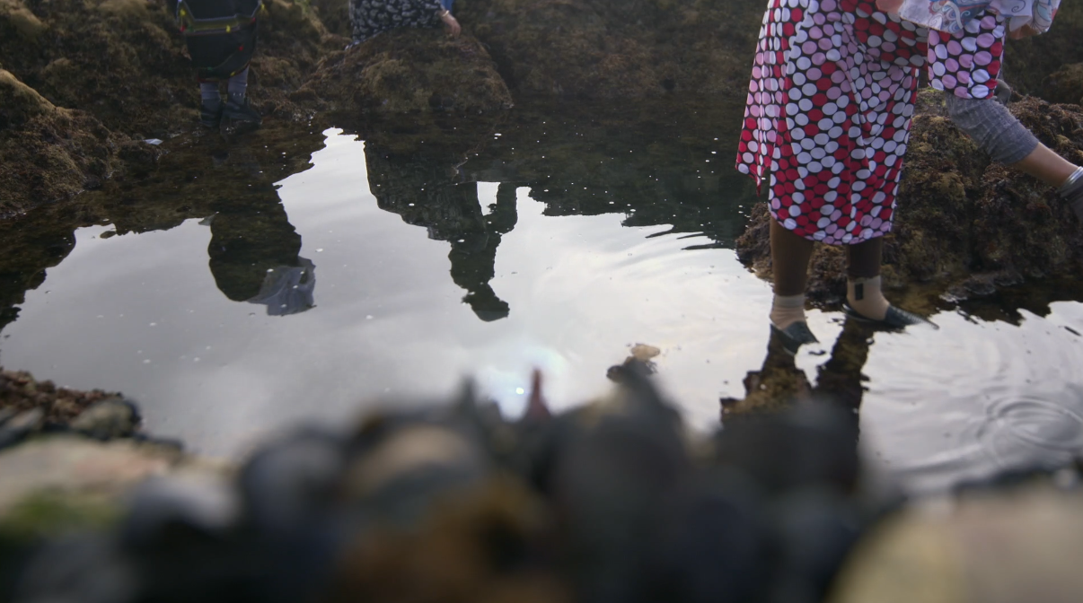 Khadija, récoltant des moules, pieds dans l’eau. Crédit Photo : ONU Femmes 